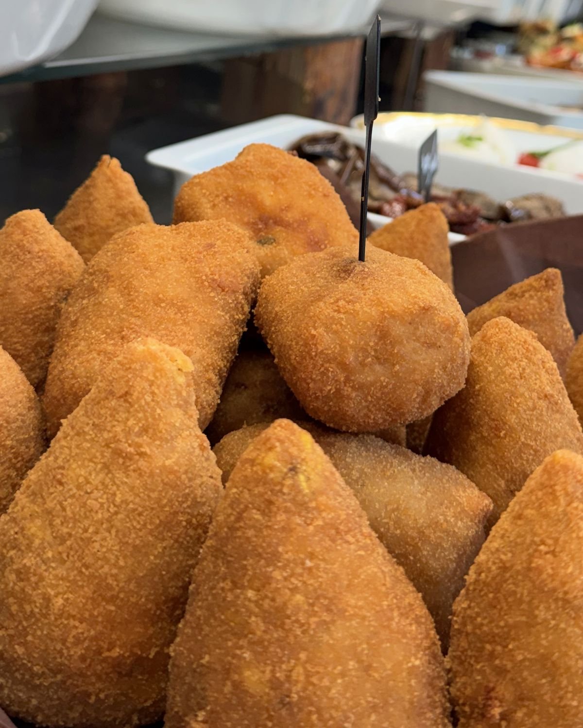 Arancini dorés, croquettes de riz panées préparées chez Yummy Italia